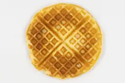 The very dark brown top crust of a waffle baked for 3 minutes using our self-mixed recipe.