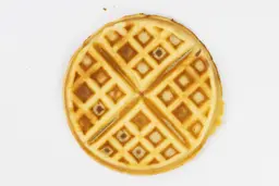 The very dark brown top crust of a waffle baked for 5 minutes using our self-mixed recipe.