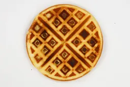 The very dark brown-dark gold bottom crust of a waffle baked for 5 minutes using our self-mixed recipe.