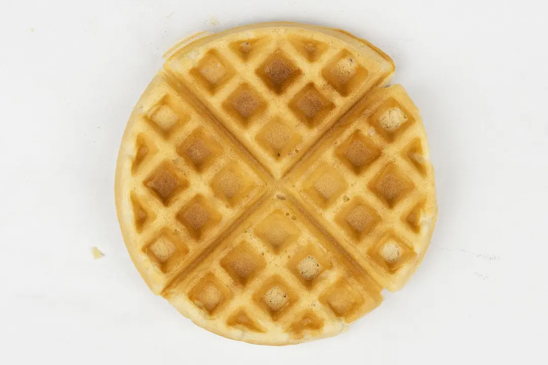 The dark brown top crust of a waffle baked in 7 minutes and 30 seconds.
