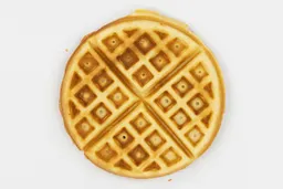 The top crust of a waffle baked for 7 minutes using our self-mixed recipe, coloration ranges from very dark brown in certain spots to light brown.