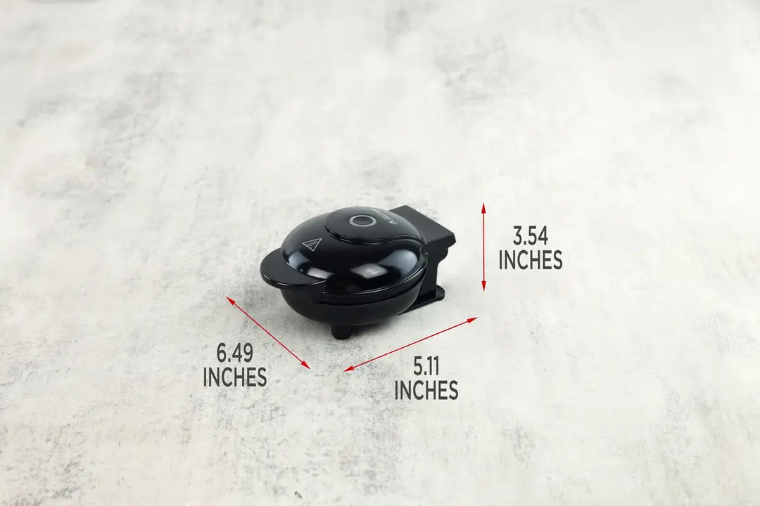 A side profile of the glossy black Holstein personal mini waffle maker.