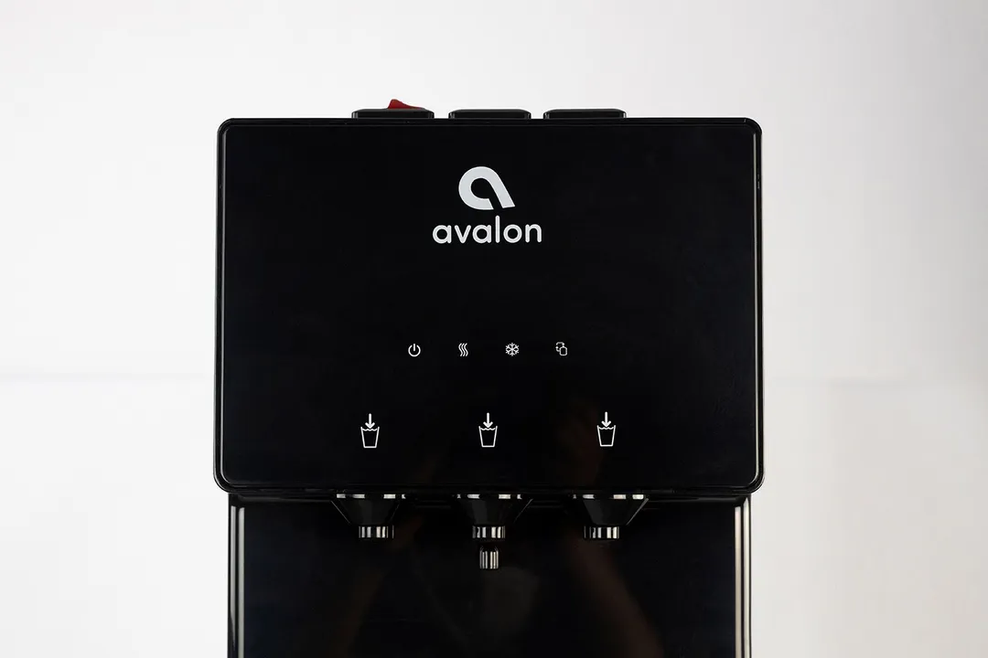 Display panel, spouts, and buttons clearly shown in a close up of an Avalon water cooler dispenser.