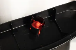 Close up of a red water float in the drip tray of a water cooler dispenser.