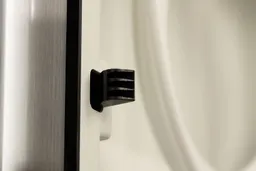 Close up of a cabinet door locking mechanism on a water cooler dispenser.