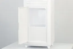 The storage cabinet of a small top loading water cooler dispenser with the door open.