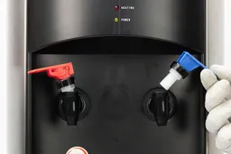 A close up view of two detached water faucets on a water cooler dispenser.