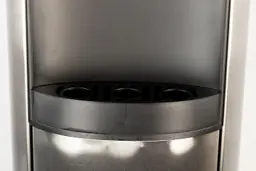 Close up front view of a drip tray positioned in a water cooler dispenser.