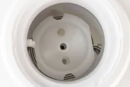 The inside of a cold water tank of a top loading water cooler dispenser showing the water baffle. 
