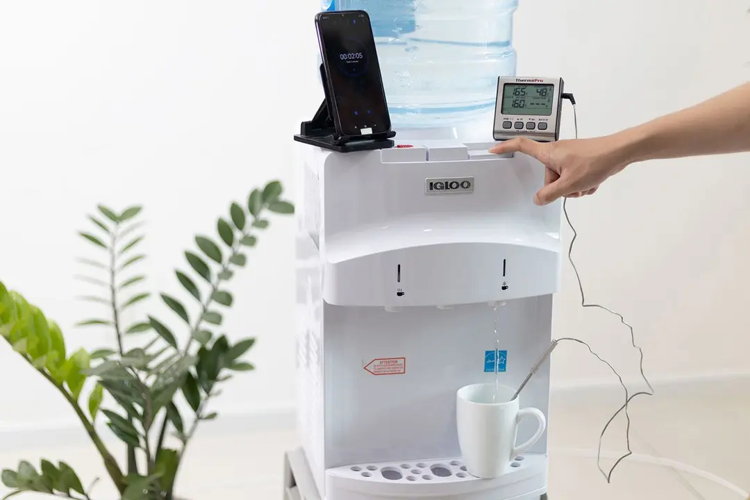 Cold water testing on the Igloo countertop water cooler dispenser. A thermometer is measuring cold water flowing into a cup.