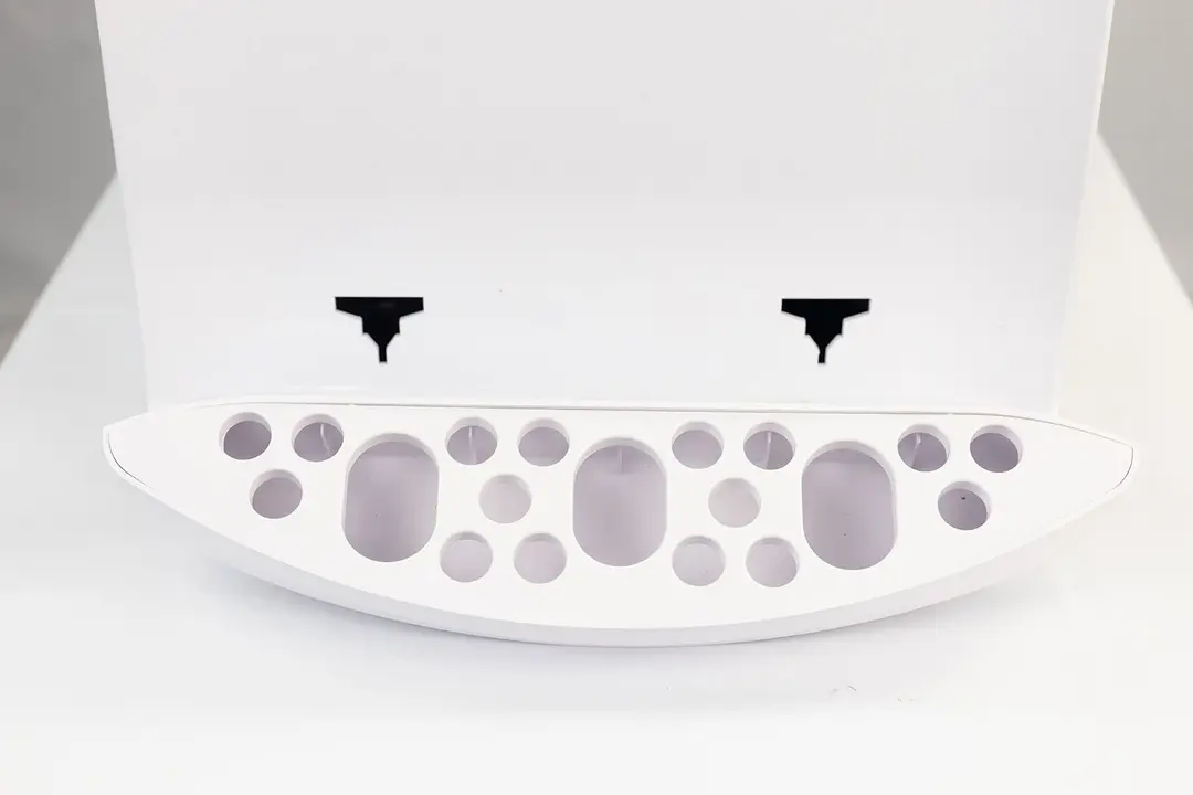 A top down view of a white colored drip tray of a small countertop water cooler dispenser.