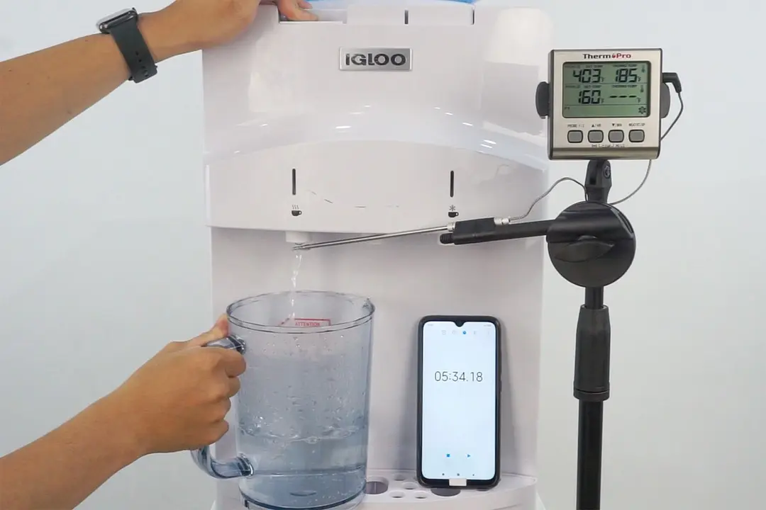 Water temperature being measured as hot water flows out the nozzle of a water cooler dispenser.