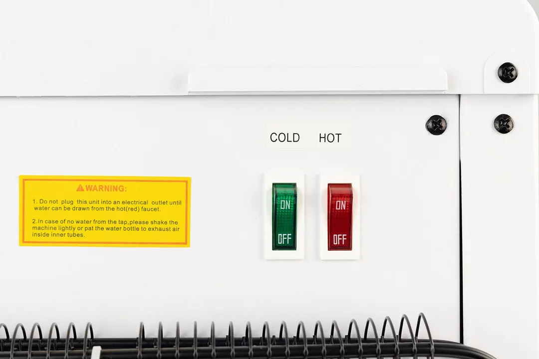 Two tank switches found on the rear of a water cooler dispenser. The right is red and the left green, both with on/off labels.
