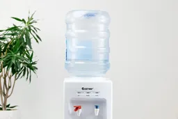 A water bottle loaded onto the Costway 5-gallon water cooler dispenser.