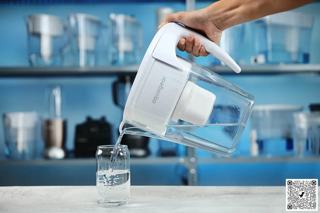 Hand holding Aquagear filter pitcher and pouring water to glass