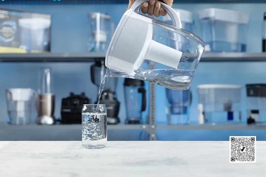 The Brita Everyday water filter pitcher next to a glass of water