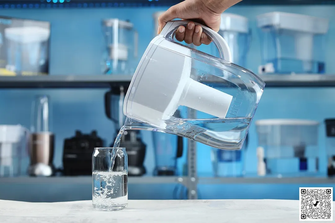 Hand holding and pouring water from the Brita Everyday to a glass