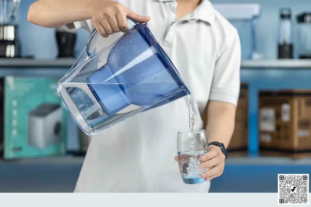 person pouring water from the Brita Marella XL to a glass