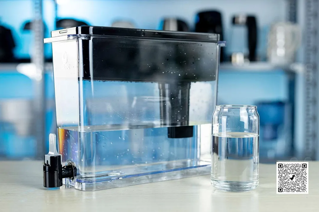 The Brita Ultramax Water Filter Dispenser (27 Cup) next to a glass of water