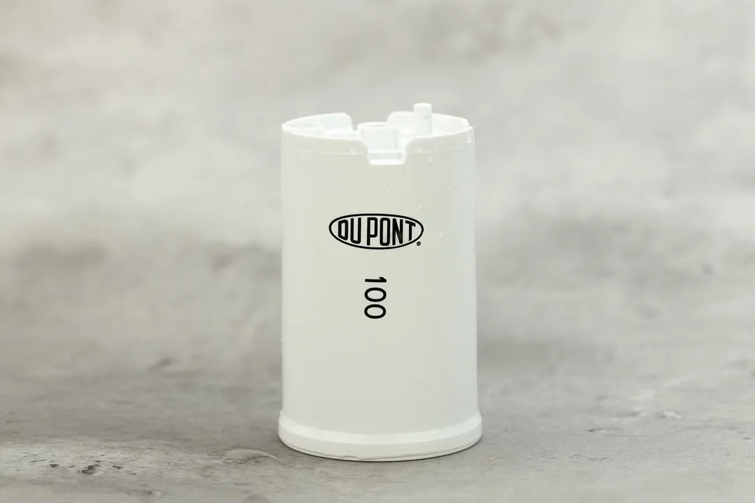 The white plastic filter cartridge that comes with the filter. Printed on it are the DuPont logo and the number 100.