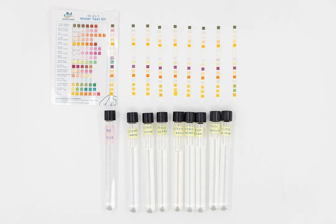 Eight test sticks arranged in a row, displaying results corresponding to the water sample vials collected from eight filters.