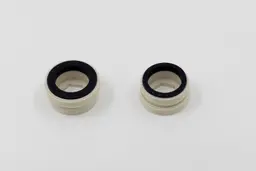Two faucet adapters made from white plastic with black rubber seals at the top