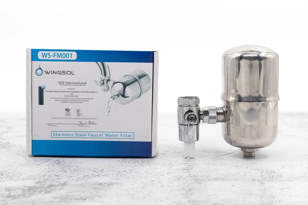 The Wingsol WS-FM001 faucet water filter on a table next to its shipping box.