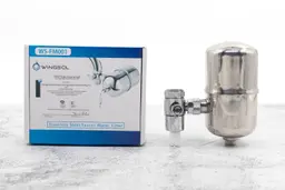 The Wingsol WS-FM001 faucet water filter on a table next to its shipping box.