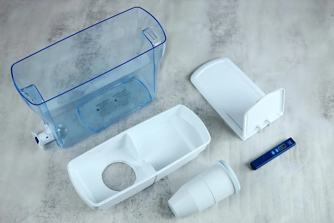parts of the ZeroWater 23 cup dispenser, including the dispenser, reservoir, lid, filter piece, and TDS meter