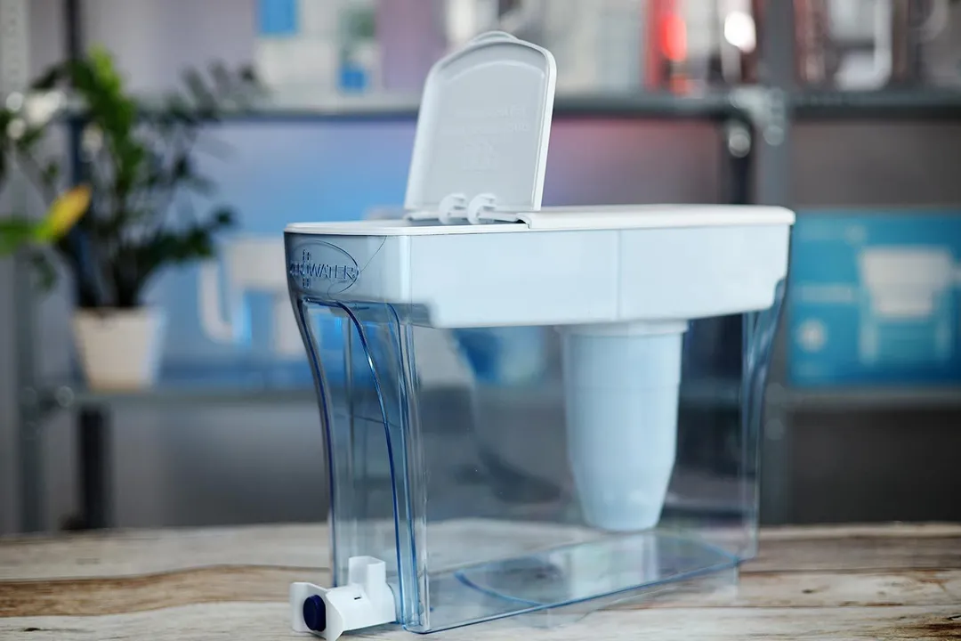 The ZeroWater 23 cup filter dispenser on a table, with part of its lid lifted up