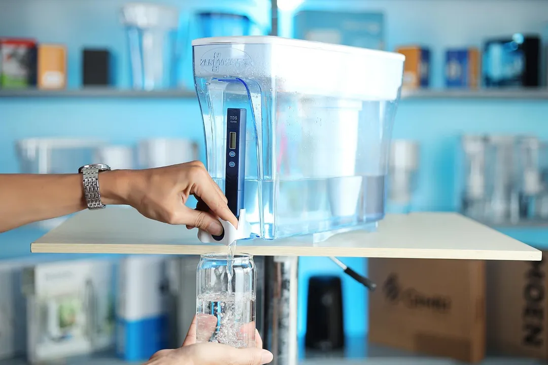 Water being dispensed from the ZeroWater 23C dispenser on a table to a glass
