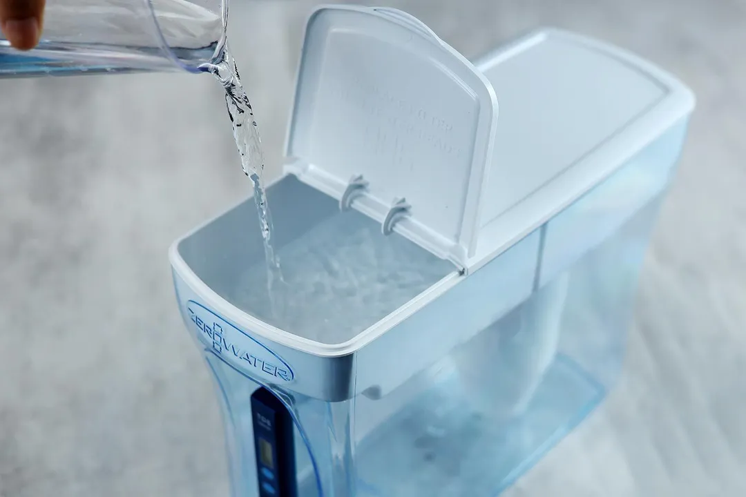 Water being poured from a clear container into the reservoir of the ZeroWater large dispenser