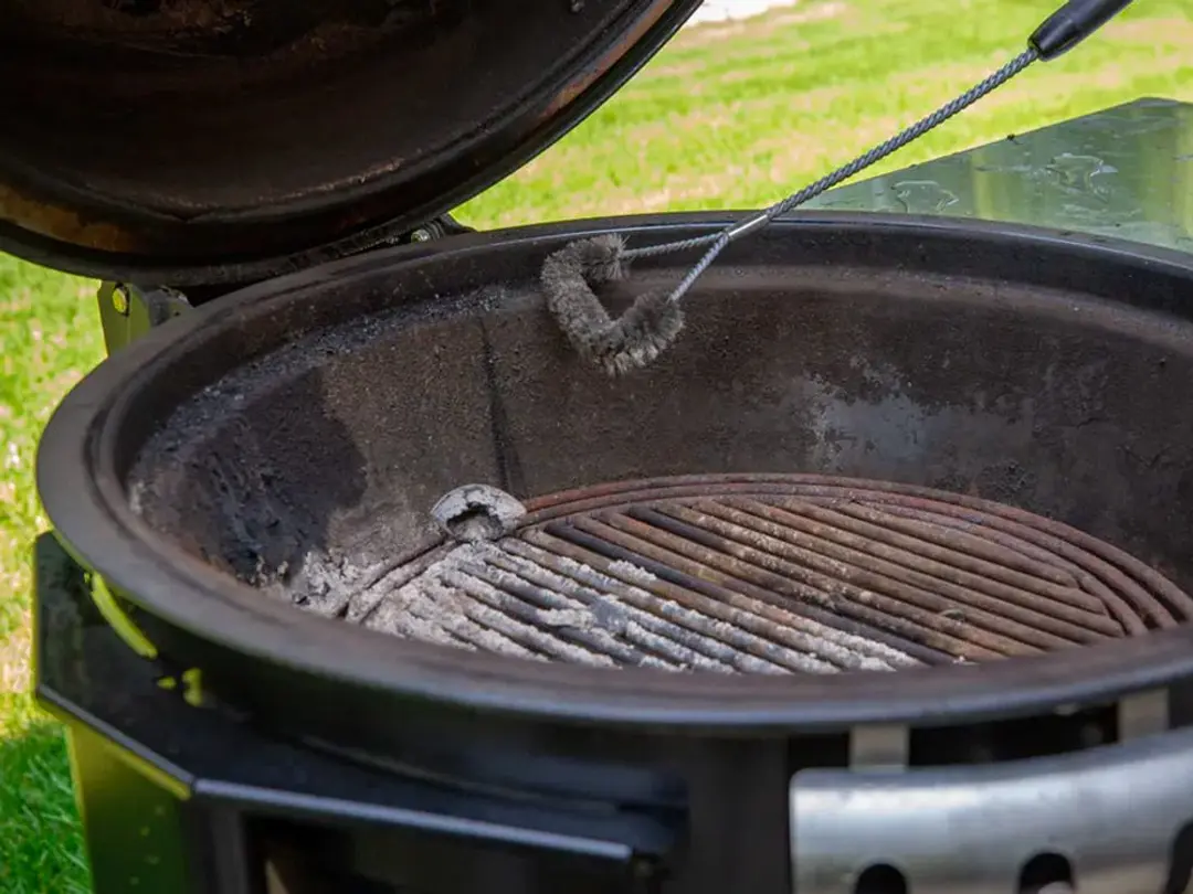 Scrubbing a charcoal grill