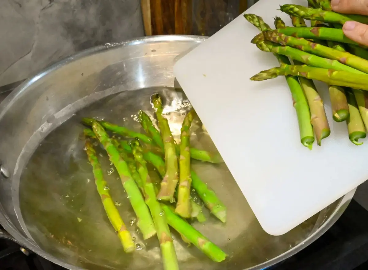 Adding asparagus slowly to the boiling water