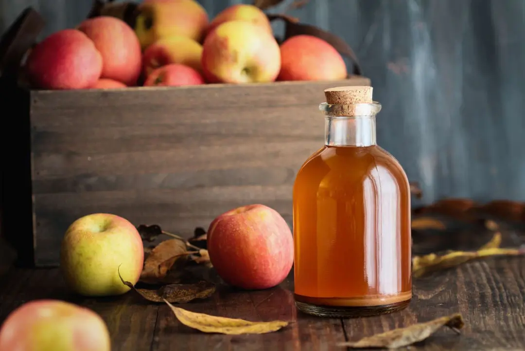 Apple cider vinegar with the mother, yeast and healthy bacteria, surrounded by fresh apples. Apple cider vinegar has long been used in naturopathy to treat things such as diabetes and high  cholesterol.